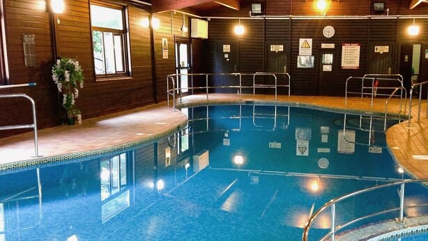 An indoor swimming pool with clear water, surrounded by wooden walls and metal railings. - Cornish Cottage in Hayle near to St Ives (Hayle)