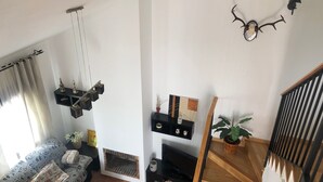 Una sala de estar con un sofá, una mesa de centro, una chimenea y una escalera.