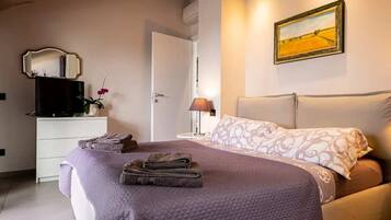 Una camera da letto con un letto, un comodino, una lampada, uno specchio e un quadro appeso al muro.