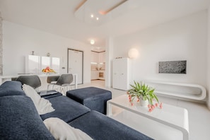 A modern living room with a sofa, a coffee table, and a potted plant.