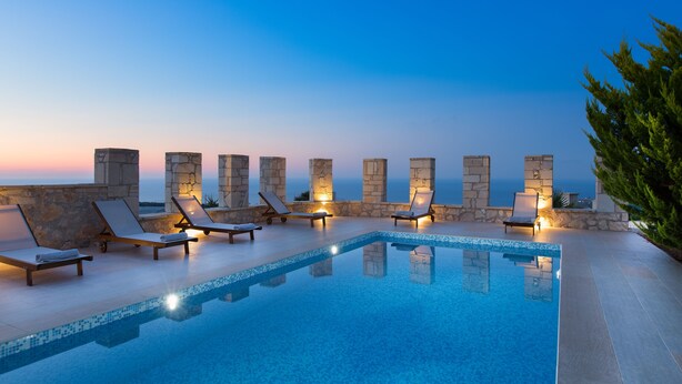 A poolside area with lounge chairs and a view of the ocean at dusk. - Only 10'min from Rethymno city (Rethymno)