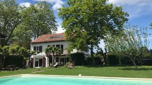 A two-story house with a swimming pool, surrounded by trees and a clear sky. - Big traditional basque villa with  enclosed garden (Ascain)