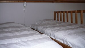 A single bed with a wooden headboard in a room with a sloped ceiling. - studios - 1 room - 2/4 persons (Annecy)