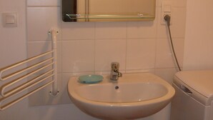 A bathroom with a pedestal sink, a mirror above it, and a towel rack to the left. - studios - 1 room - 2/4 persons (Annecy)