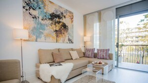 Un salon moderne avec un canapé, une table basse, une lampe et un grand tableau abstrait.
