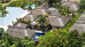A resort with thatched-roof bungalows surrounded by lush greenery and a swimming pool. - Villa Navani - 3 bedroom, 3 ensuite bathroom, private and garden daily cleaning (Pereybere, Grand Baie)