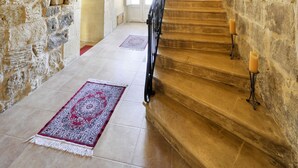 A stone staircase with a red carpet leading to a landing. - Tal-barun Farmhouse (San Lawrenz)