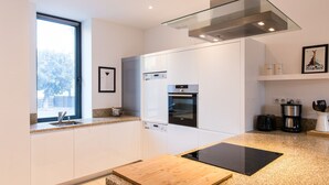 A modern kitchen with a built-in oven, a coffee maker, and a toaster. - Spacious Central Apartment with Terrace (Chamonix-Mont-Blanc)
