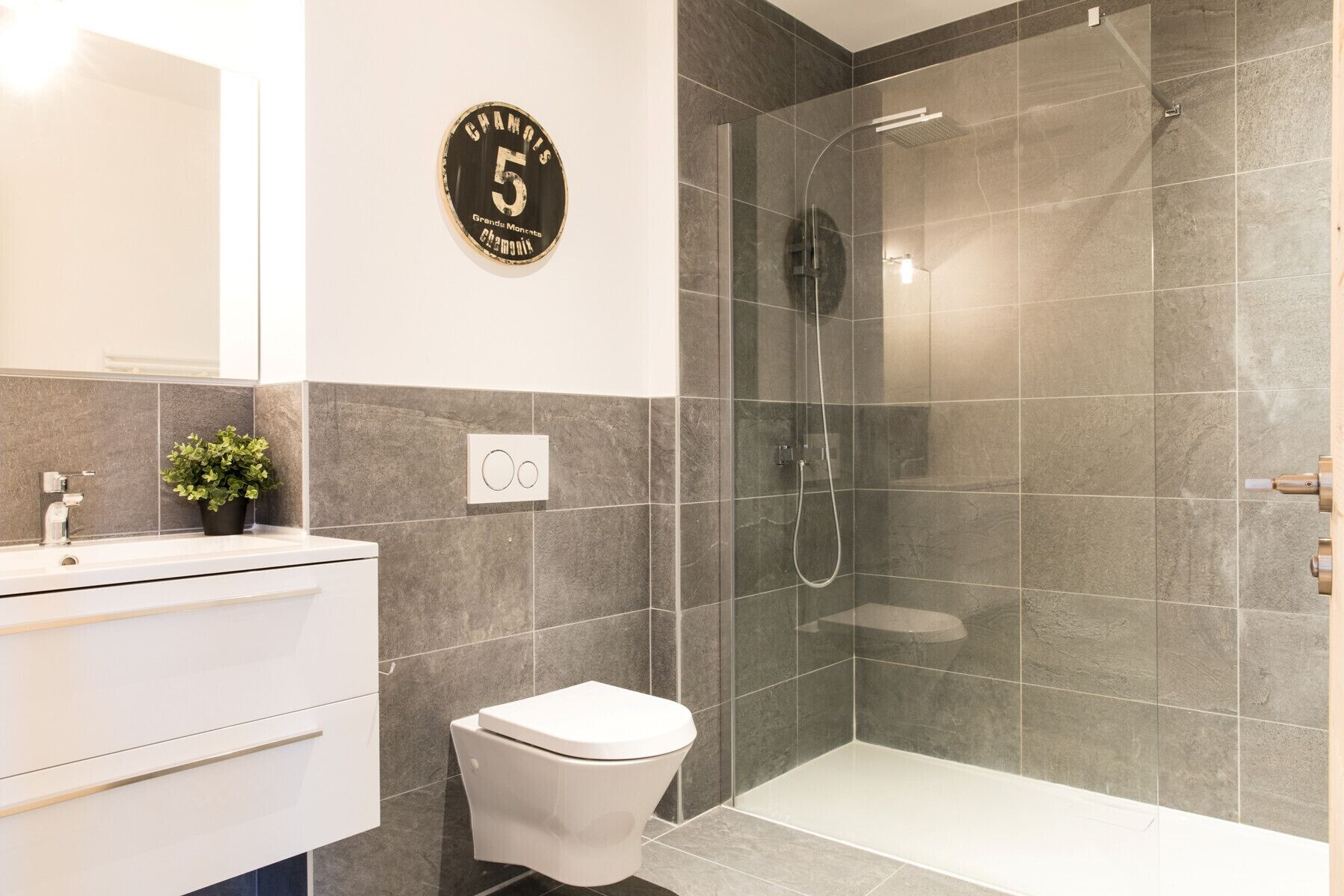 Un baño moderno con ducha, inodoro y lavamanos.