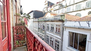 Un estrecho callejón entre edificios, con una barandilla de metal rojo.
