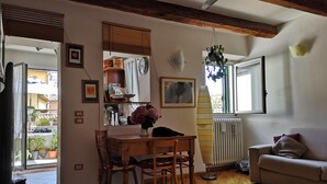 Una sala de estar acogedora con una mesa de comedor de madera, un sofá y un ventanal con vistas al exterior.