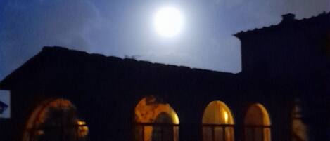 Un edificio con ventanas de arco y una luna en el cielo.