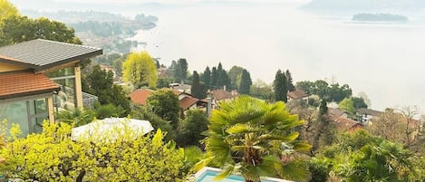 Una piscina con vistas a un lago y casas circundantes.