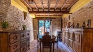 Una cocina rústica con paredes de ladrillo visto, armarios de madera y suelo de piedra.