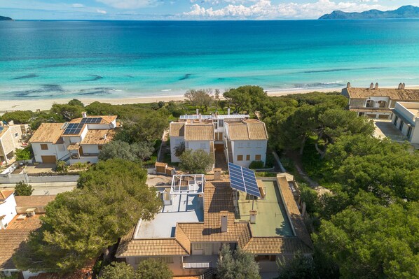 A coastal residential area with houses featuring solar panels and a view of the sea.