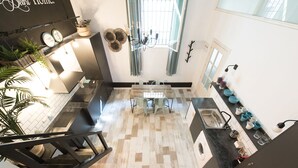 Une cuisine moderne avec un coin repas, un escalier et une vue sur le salon.