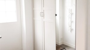 A hallway with white walls and doors, leading to a room with a window. - Nice home in Skillingaryd with kitchen (Skillingaryd)