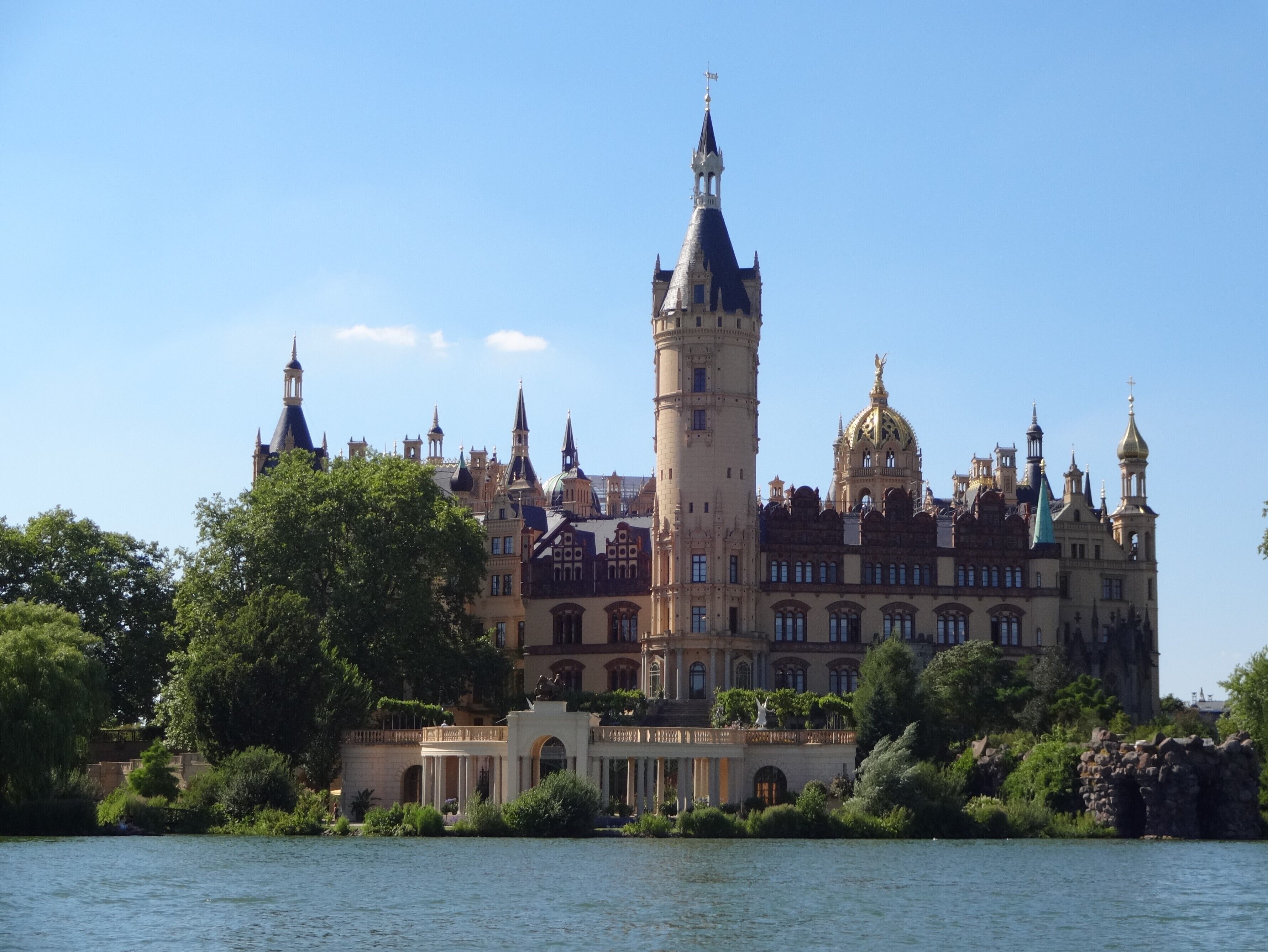 A historic building with a prominent tower, multiple spires, and a large dome.