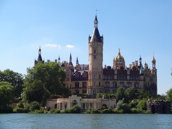 A historic building with a prominent tower, multiple spires, and a large dome.