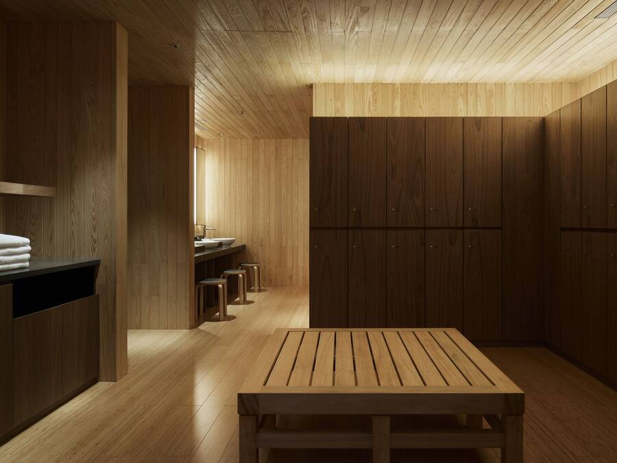 A wooden interior with a bench, wooden cabinets, and a sink area.