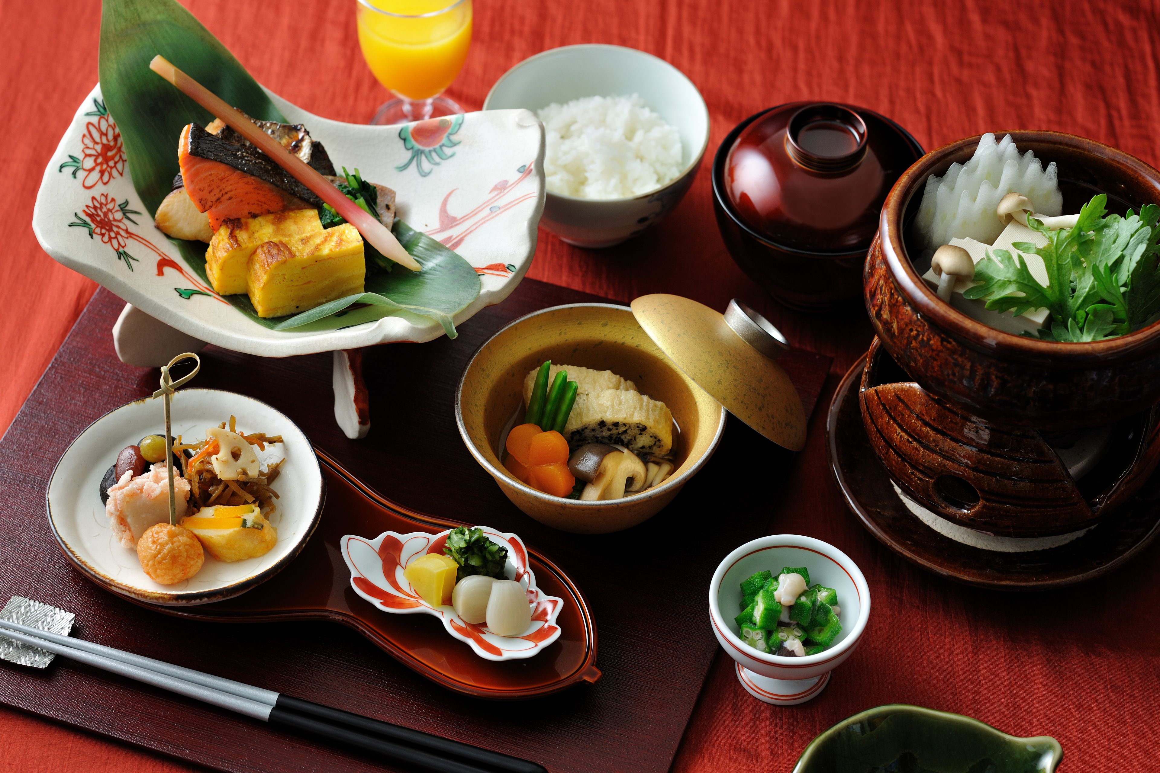 A variety of Japanese dishes including sushi, rice, and soup on a wooden table.