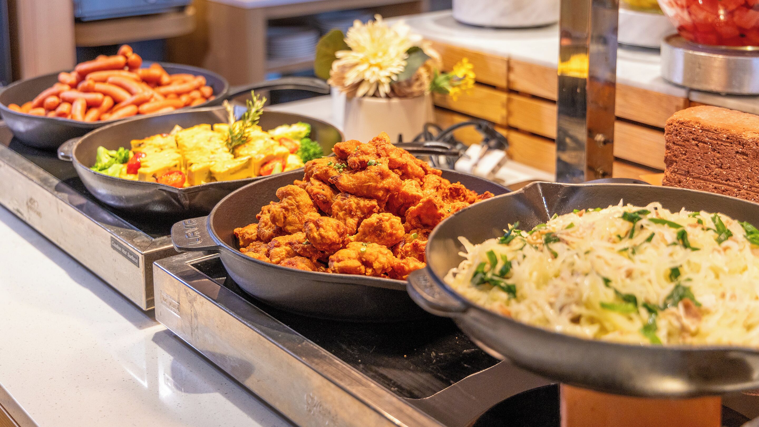 A buffet with various dishes including fried chicken, rice, and vegetables.