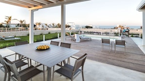 An outdoor patio with a pool, dining area, and beach view. - Villa Ulivo for 8 People in Sicily, Pool, Sea View, Garden, Wifi and A/C (Reitani)