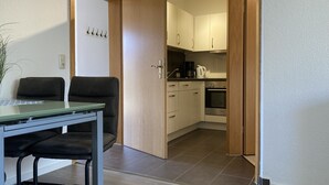 A modern kitchen with wooden cabinets, a built-in oven, and a coffee maker. - The "Seepferdchen" in Haus Meeresglück, close to the beach and central! (Dahme)