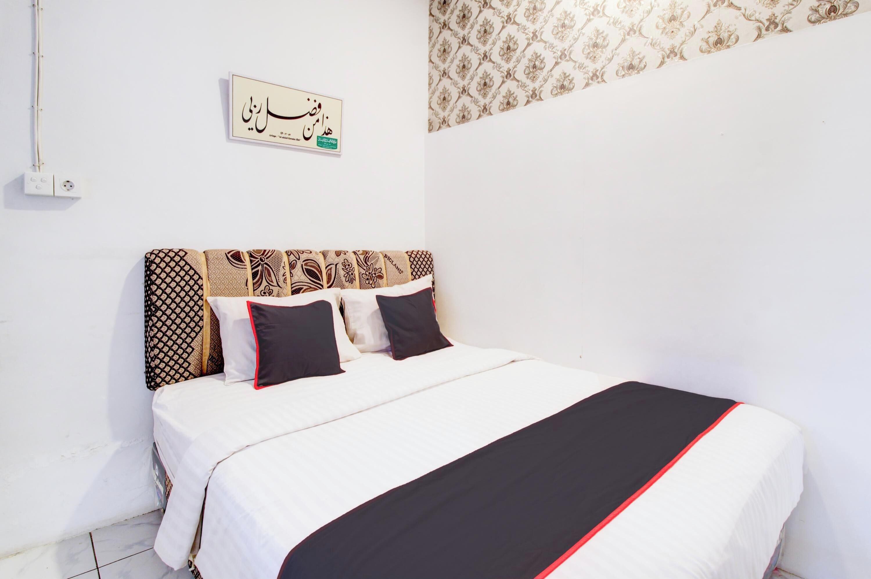 Una cama bien hecha con almohadillas estampadas y una colcha blanco y negro.