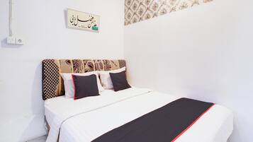 Una cama bien hecha con almohadillas estampadas y una colcha blanco y negro.