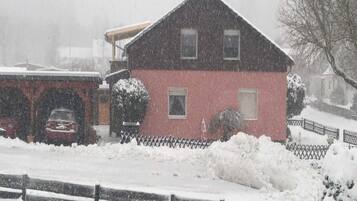 Ein rotes Gebäude mit einem schwarzen Dach, umgeben von Schnee.