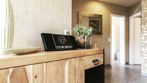 Eine Holztresen mit einem schwarzen elektronischen Gerät, einem Blumentopf und einer weißen Schüssel.