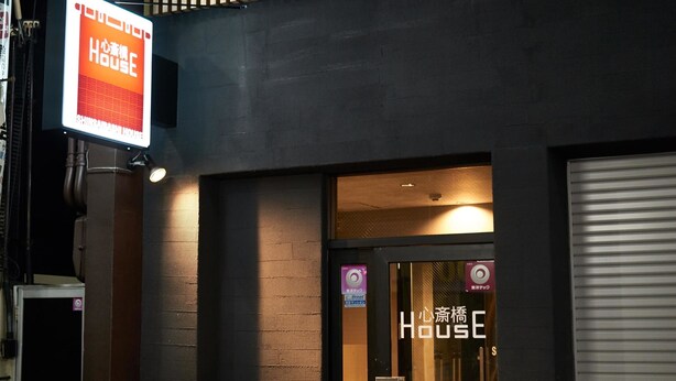 A modern building with a sign for 'House' and a large white cabinet outside. - WELLSTAY　Osaka　Shinsaibashi Apartment hotel (Osaka)