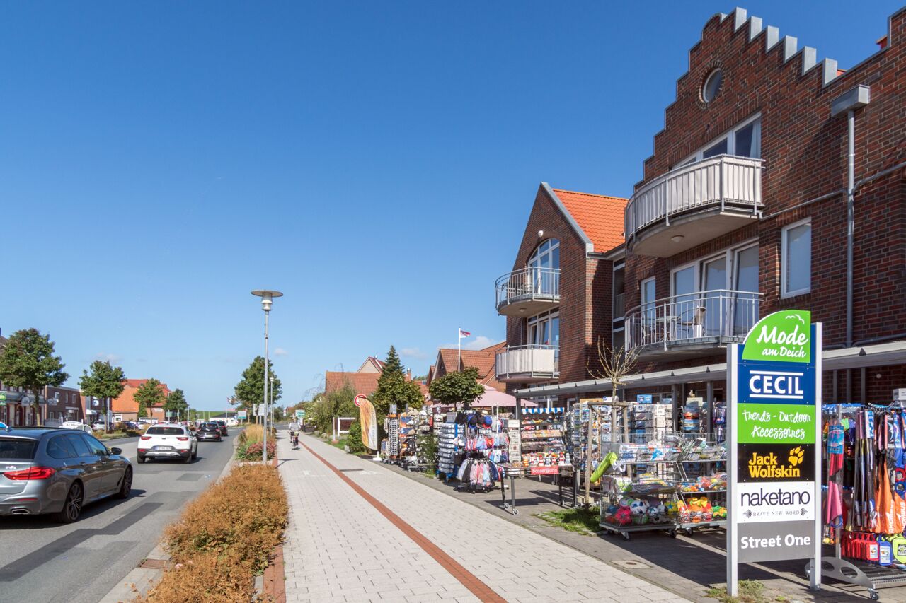 Straßenansicht mit einem Backsteinhaus, einem Bürgersteig und einem Schild für den Laden CECIL.