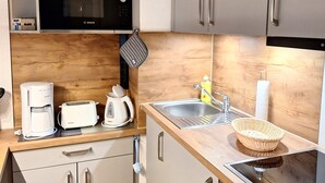 Eine moderne Küche mit einer Bosch-Mikrowelle, einer Kaffeemaschine, einem Toaster und einem Spülbecken.