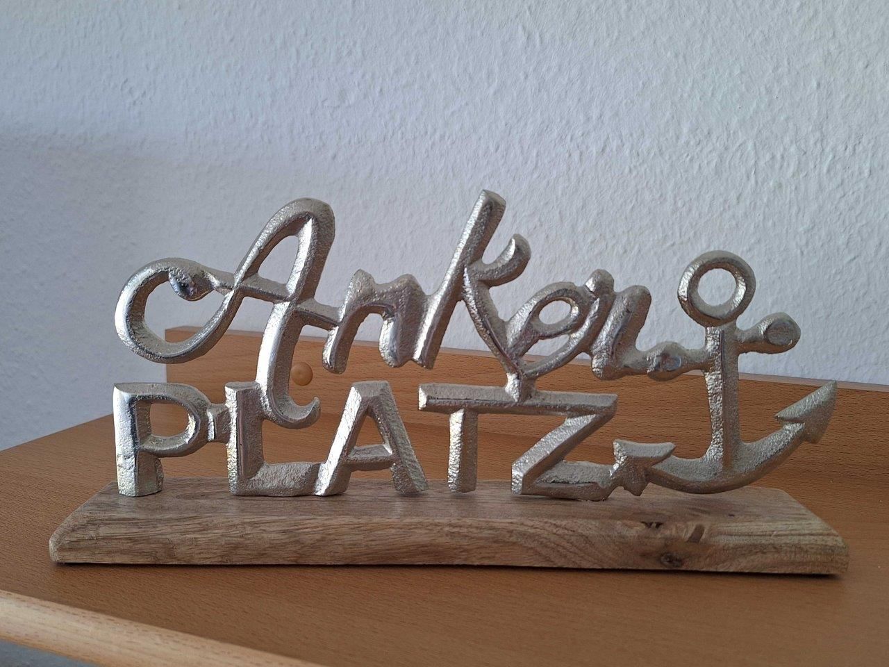 A metal sign with the words "Ankerplatz" on a wooden base.