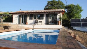 A house with a swimming pool, a patio with outdoor furniture, and a solar panel array. - Eco house with pool and fantastic views (Scansano)