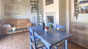 A rustic dining area with a wooden table and chairs, a fireplace, and a brick floor. - UNIQUE LARGE TERRACE WITH VIEWS TO CHAINTI VALLEY AND DRINK (Ruffoli)