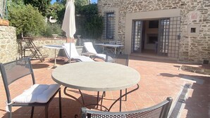 An outdoor patio with a round table and chairs, surrounded by stone walls and a tall tree. - UNIQUE LARGE TERRACE WITH VIEWS TO CHAINTI VALLEY AND DRINK (Ruffoli)