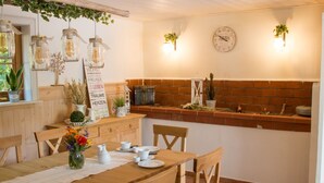 Una cocina acogedora con pared de ladrillo, armarios de madera y una mesa para cuatro comensales.