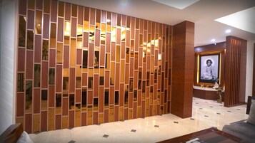 Un interior moderno con un tabique de madera, un retrato enmarcado y un suelo de mármol.