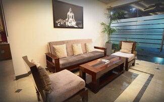 Una sala de estar con un sofá, dos sillones, una mesa de centro y un cuadro en la pared.