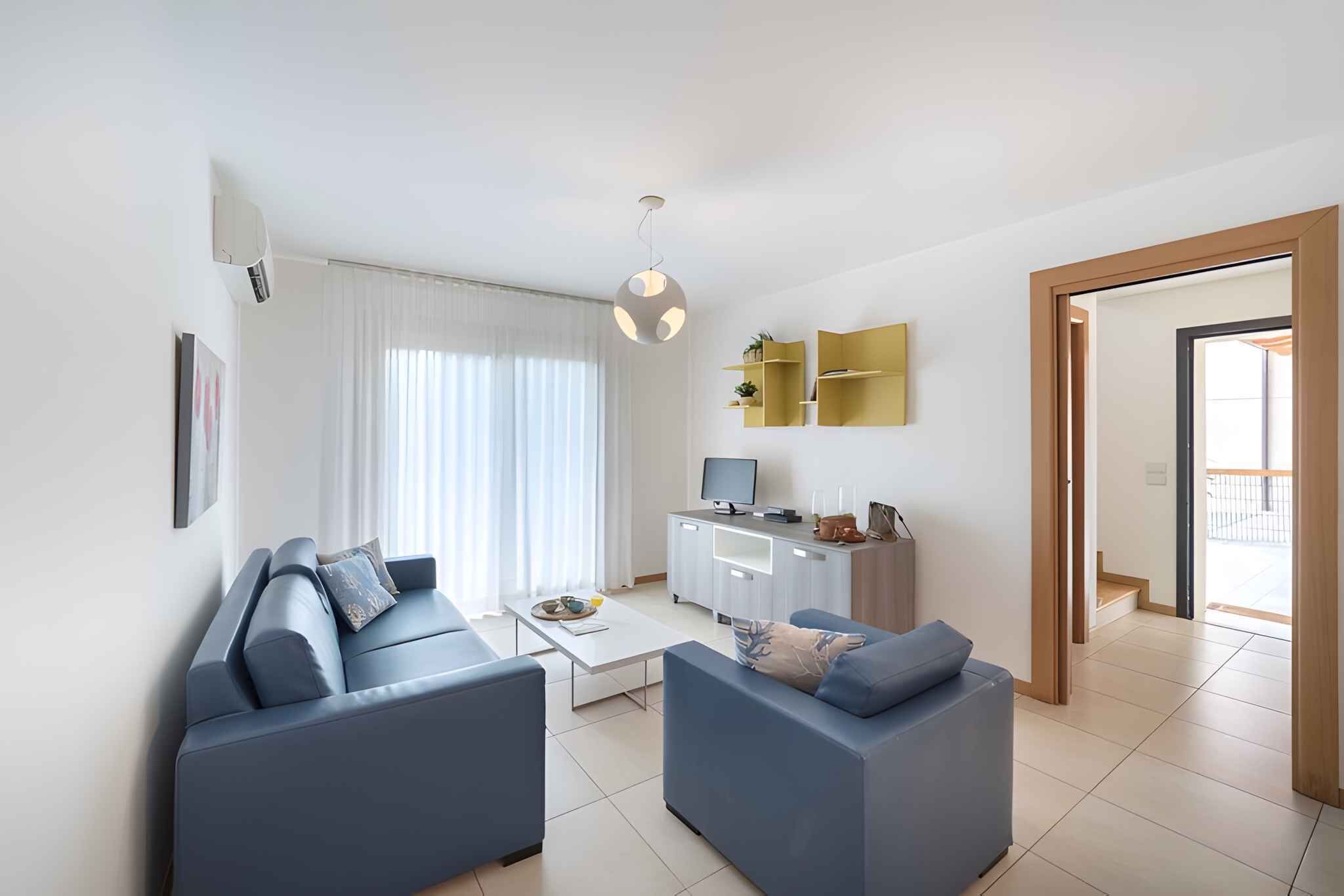 A modern living room with a sofa set, a coffee table, a TV, and a cabinet.