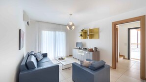 A modern living room with a sofa set, a coffee table, a TV, and a cabinet.