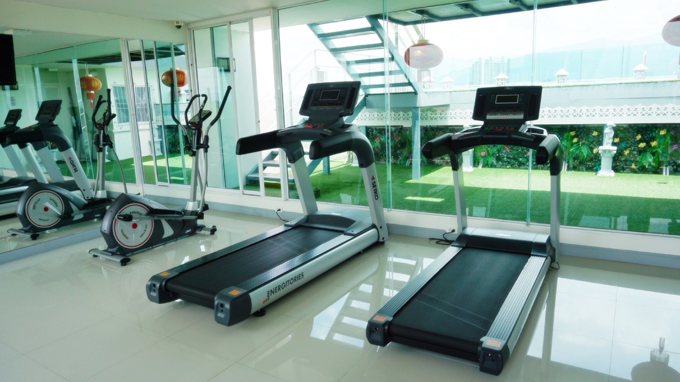 A gym with treadmills, stationary bikes, and elliptical machines.