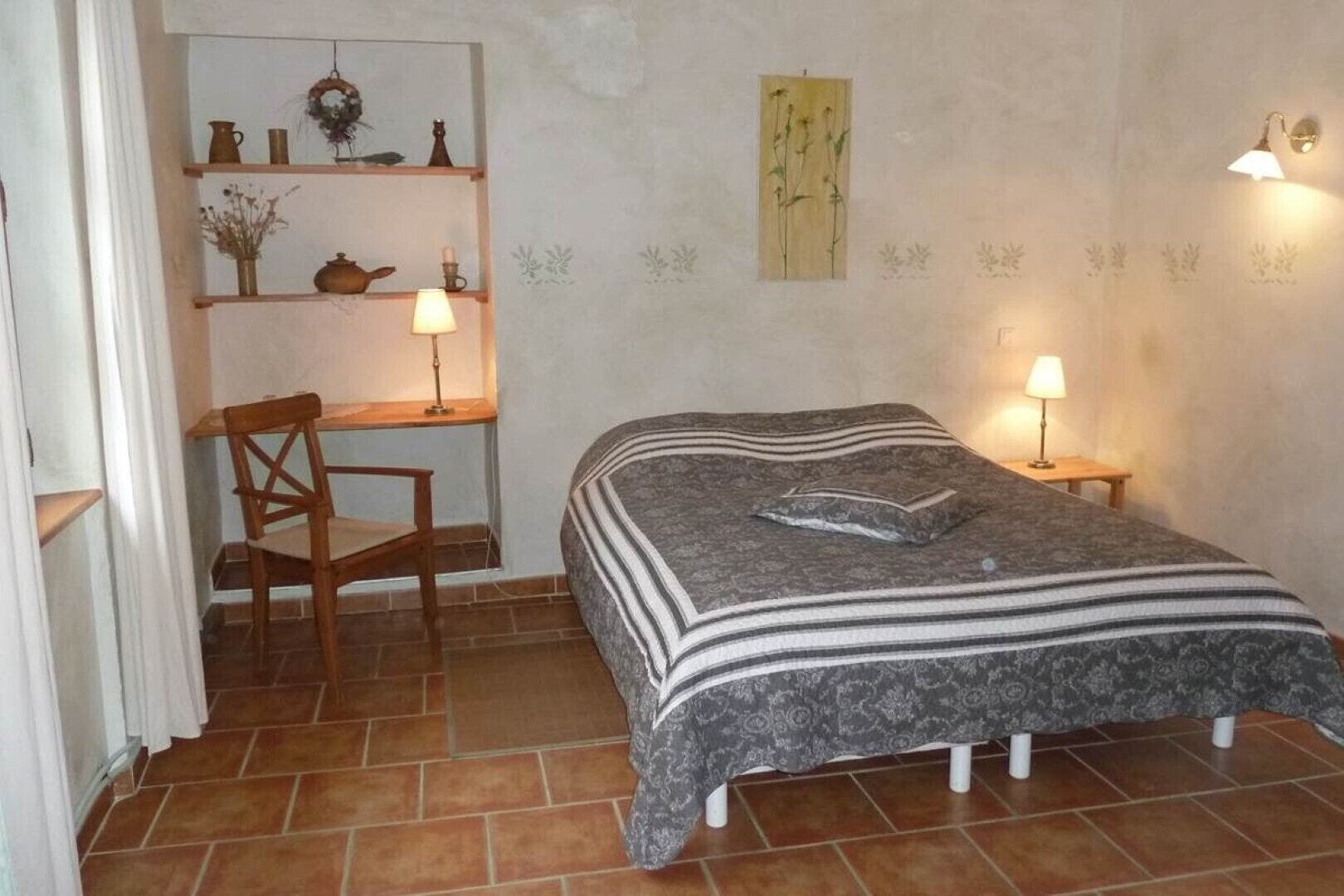 Une chambre à coucher avec un lit, un bureau et deux lampes.