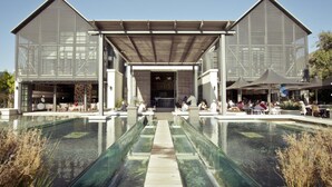 A modern building with a covered patio area and a central pool. - Whalesong Glencairn (Cape Town)