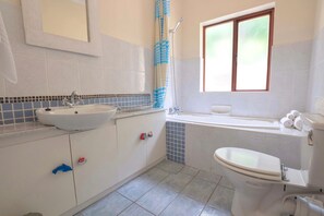 Un bagno con lavandino, WC e vasca da bagno.