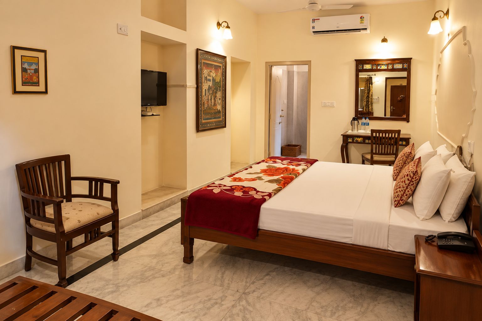 A hotel room with a bed, a chair, a desk, a television, and a bathroom door.