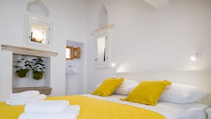 A neatly made bed with yellow and white bedding, two yellow pillows, and a white headboard. - Dubrovnik old city Studio apartment (Dubrovnik)